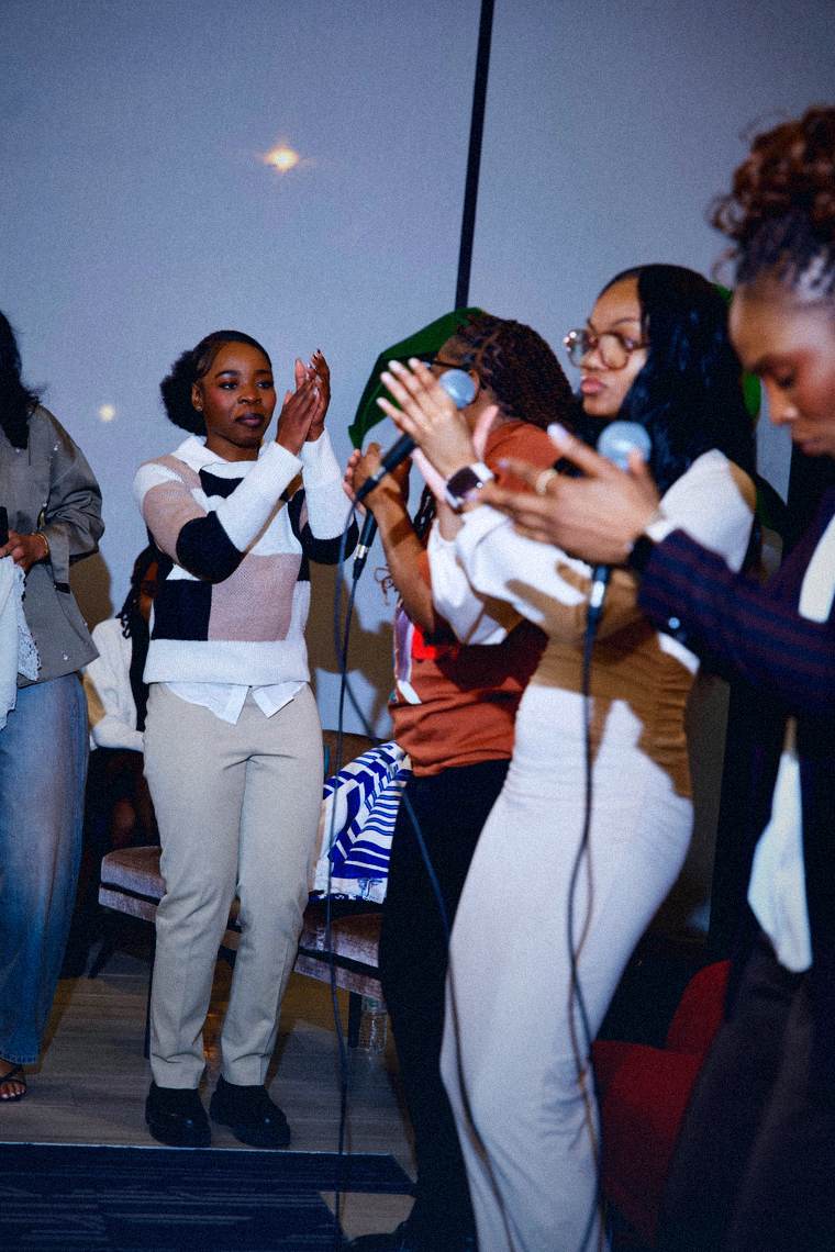 Worship team members singing and clapping