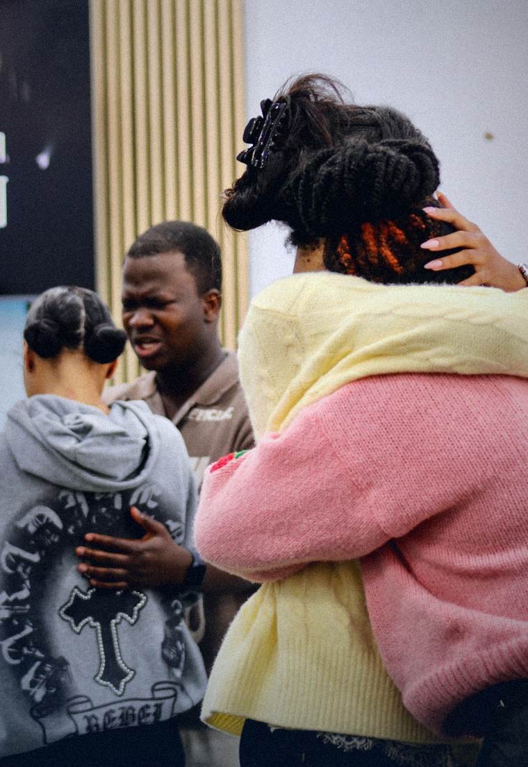 Believers embracing and praying with one another