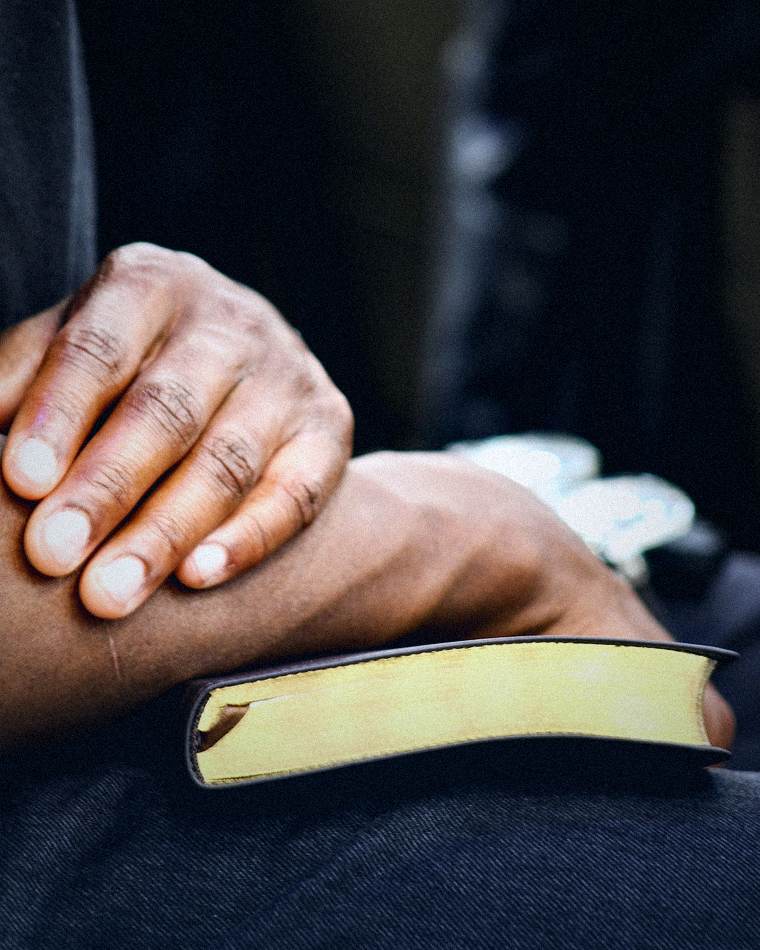 Hands resting on a gold-edged Bible