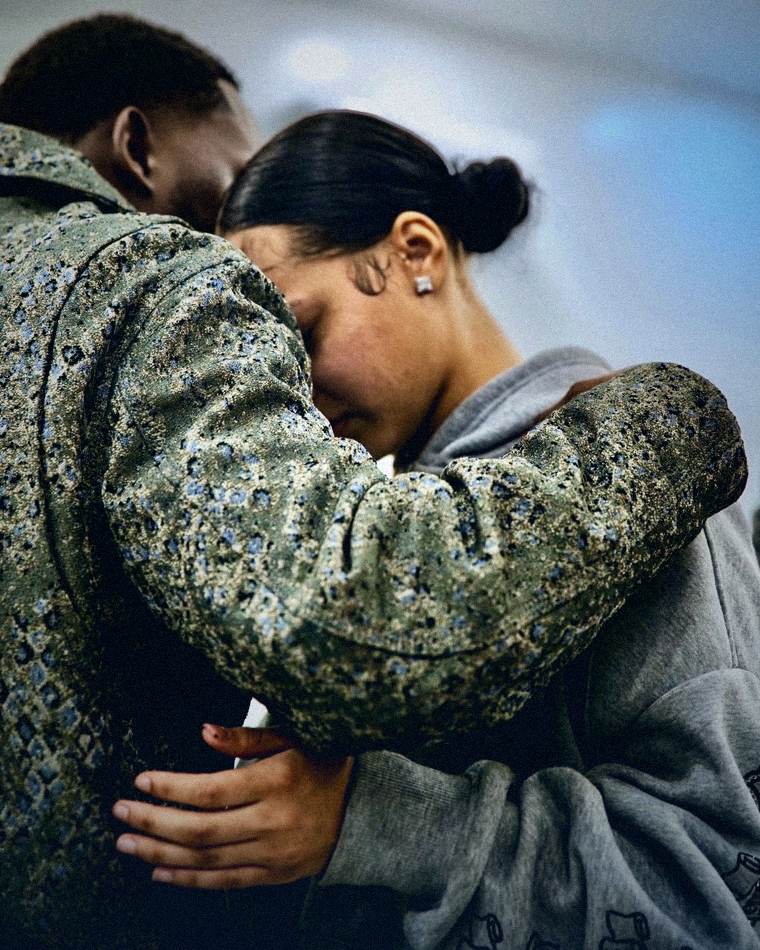Two people embracing in prayer