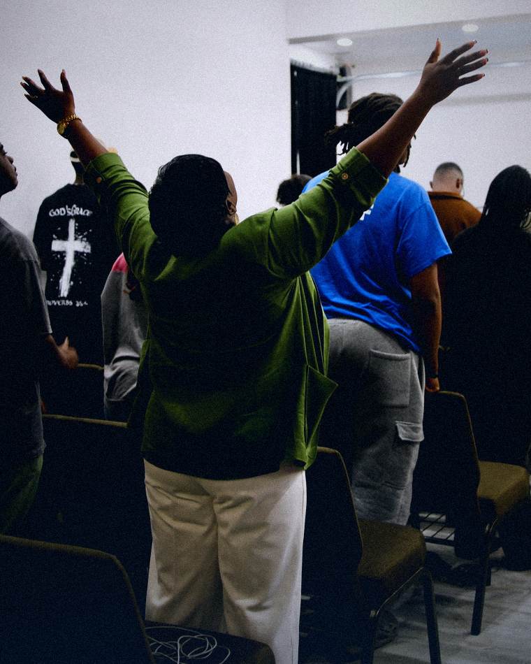 A woman worshipping with both arms lifted