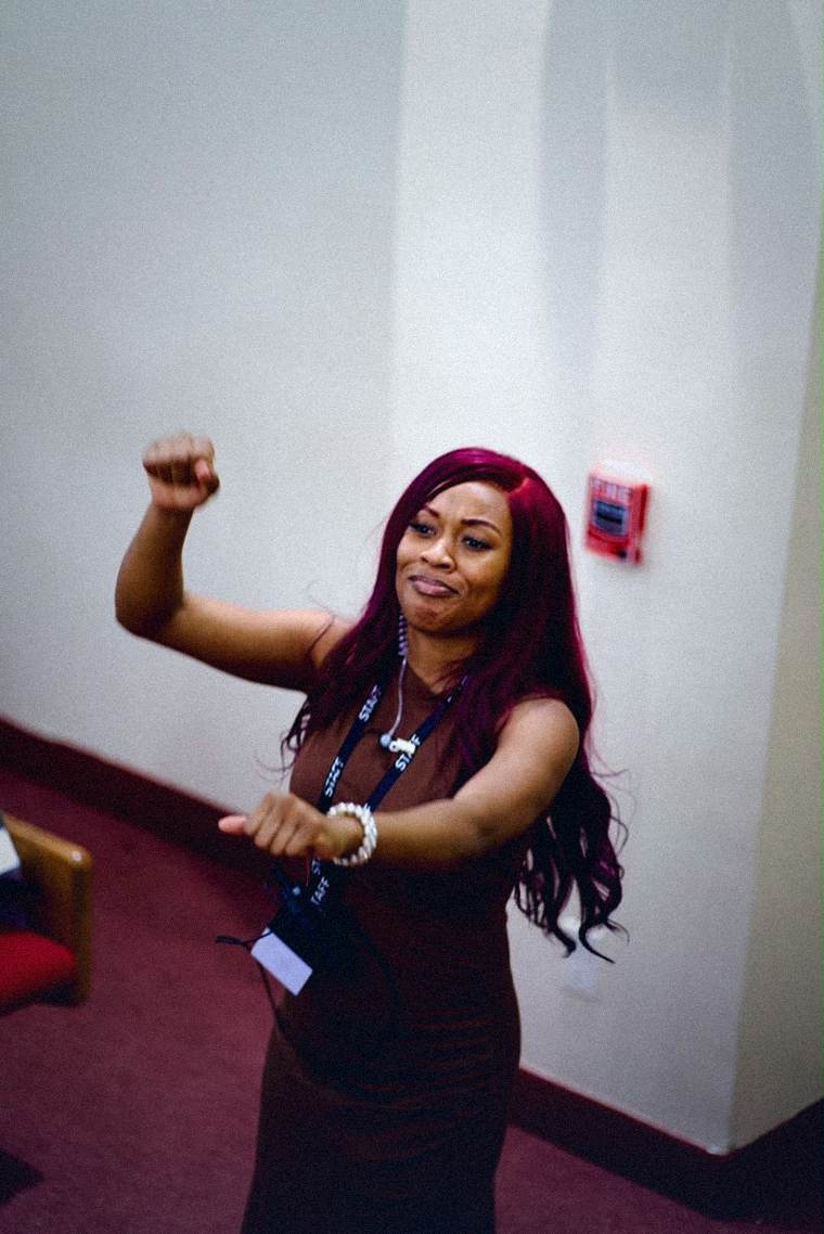 A staff member serving with her arms raised